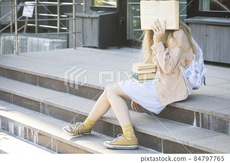 girl with books sitting on the steps girl with books sitting on the steps 84797765