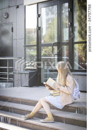 girl with books sitting on the steps girl with books sitting on the steps 84797766