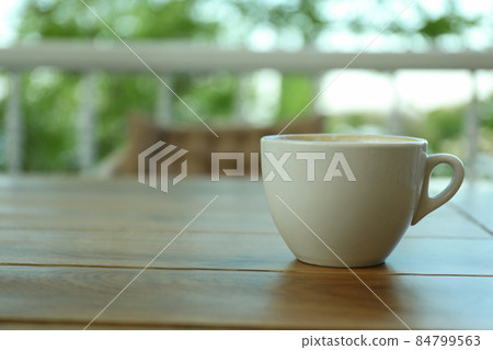 Cup of coffee on wooden table in restaurant 84799563