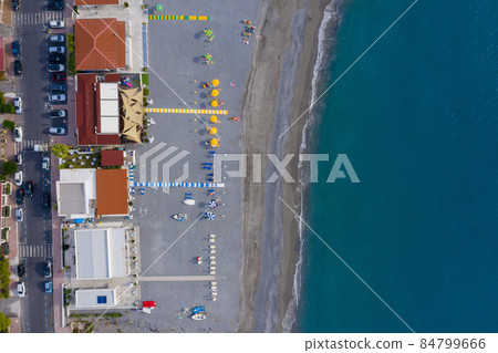 Tourists relaxing and sunbathing on Mediterranean pebble sea beach, aerial top view 84799666