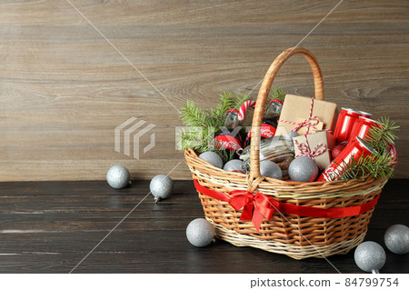 Odessa, Ukraine - November 10, 2021: Concept of gift with Christmas basket on dark table Odessa, Ukraine - November 10, 2021: Concept of gift with Christmas basket on dark table 84799754