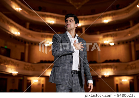 talented actor performing a monologue in theater to audience, talented brunette guy portrait 84800235