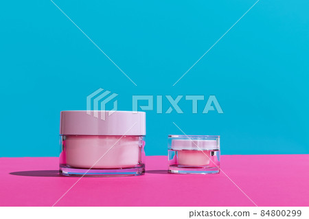 Jars of facial cosmetic cream with copy space for your brand isolated on bright colored background. Mockup 84800299