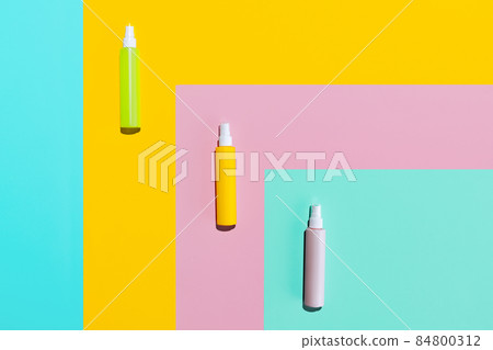 Three colored jars, spray bottles for cosmetics, cream, lotion without logos isolated over colored background. Three colored jars, spray bottles for cosmetics, cream, lotion without logos isolated over colored background. 84800312