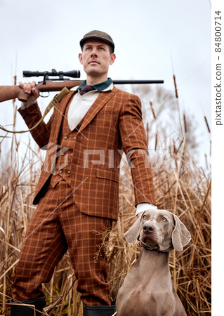 portrait of handsome guy in suit with gray dog on hunting, looking at side. down view 84800714