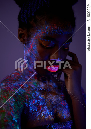 sensual woman with black skin in fluorescent paint makeup, posing at camera sensual woman with black skin in fluorescent paint makeup, posing at camera 84800909