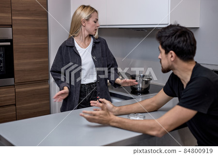 Boyfriend and girlfriend are arguing at home. Angry woman is yelling at boyfriend. 84800919