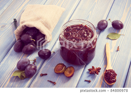 Vintage photo, Fresh plum marmalade in jar, ripe fruits and spices on boards, healthy sweet dessert 84800978
