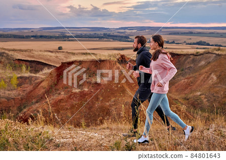 man and woman jogging in mountains wearing sportive clothes, practice running man and woman jogging in mountains wearing sportive clothes, practice running 84801643
