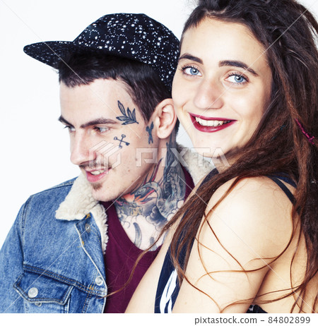 Young couple together. guy with tattoo, girlfriend wearing dreadlocks having fun on white background Young couple together. guy with tattoo, girlfriend wearing dreadlocks having fun on white background 84802899