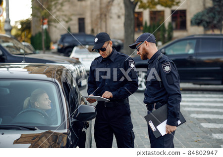 Male police officers checking the driver's license 84802947