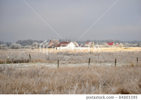 Winter. The sunbeam illuminates the house. Winter. The sunbeam illuminates the house. 84803395