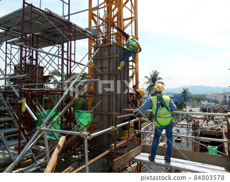 MALACCA, MALAYSIA -MARCH 25, 2016: Construction workers fabricating column timber form work and reinforcement bar at the construction site in Malacca, Malaysia.  84803578