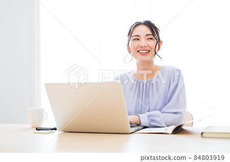 Female working by a bright window 84803919