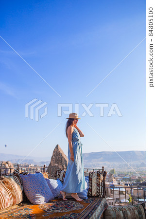 Happy young woman during sunrise watching hot air balloons in Cappadocia, Turkey 84805100