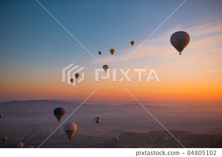 Hot air balloon flying over rocky landscapes in Cappadocia with beautiful sky on background 84805102