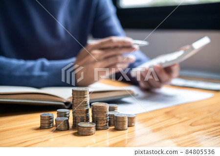 Image of coin pile focus, Young man and pile coins to planning growing saving strategy with pile coins for future plan fund of travel, education, home and retirement 84805536