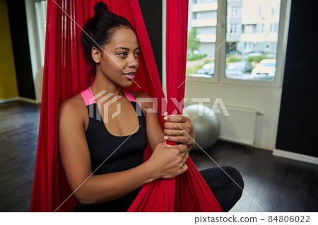 Woman doing fly yoga stretching exercises in hammock. Fit and wellness lifestyle Woman doing fly yoga stretching exercises in hammock. Fit and wellness lifestyle 84806022