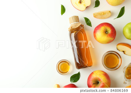 Homemade apple vinegar and ingredients on white background Homemade apple vinegar and ingredients on white background 84806169