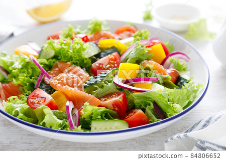 Salted salmon salad with fresh green lettuce, cucumbers, tomato, bell pepper and red onion. Ketogenic, keto or paleo diet lunch bowl 84806652