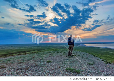 Back view young male hiker looks at sea and horizon 84807582