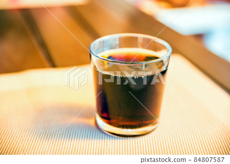Cold cola in a glass on a table 84807587