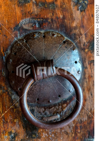 Ancient bronze handle in oriental style on wooden surface 84807617