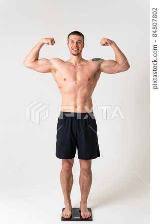 Man with weights health pondered, health and sports on a white background hurt ill sick white health adult, expression. Tension neck lower suffer attractive Man with weights health pondered, health and sports on a white background hurt ill sick white health adult, expression. Tension neck lower suffer attractive 84807802
