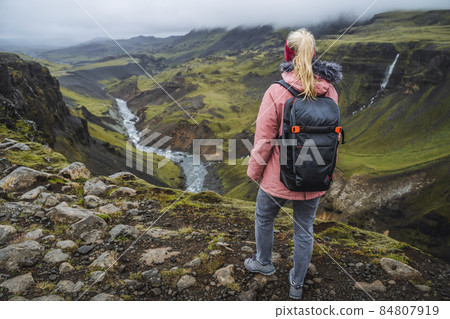 Close up of a woman with backpack enjoying icelandic highland and river fossa close to Haifoss waterfall in Iceland 84807919