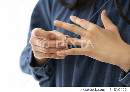 A woman who puts a wedding ring on her left ring finger A woman who puts a wedding ring on her left ring finger 84810422
