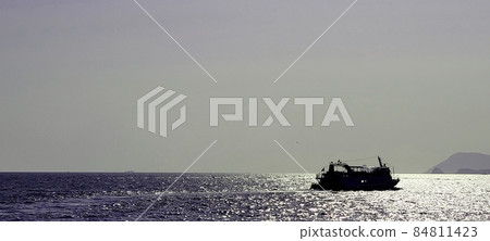 Silhouette of a fishing boat passing the sea off Haeundae, Busan in the late afternoon 84811423