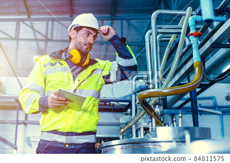 Factory worker Hispanic engineer working in factory checking maintenance pipe boiler system in factory. Factory worker Hispanic engineer working in factory checking maintenance pipe boiler system in factory. 84811575