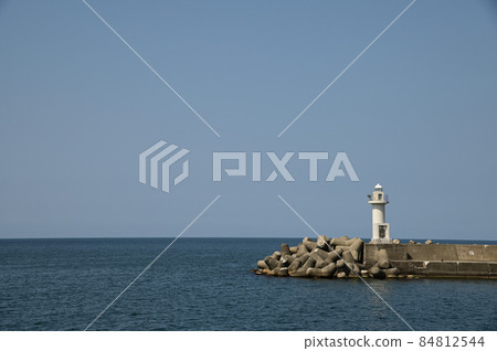 View of the horizon from a calm fishing port with a lighthouse View of the horizon from a calm fishing port with a lighthouse 84812544