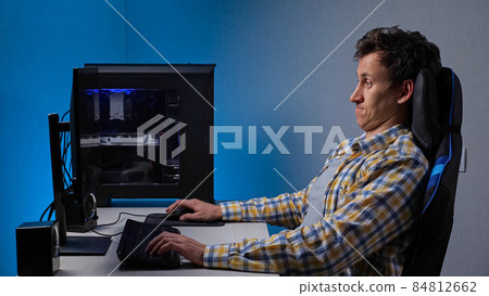Addicted to games man plays constantly sitting at computer Addicted to games man plays constantly sitting at computer 84812662