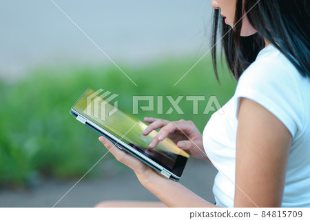 Young girl in the park learning with tablet 84815709