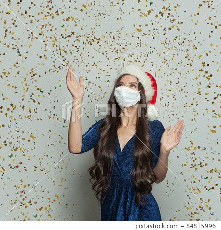 Happy Santa woman in protective mask and falling confetti. Christmas 84815996