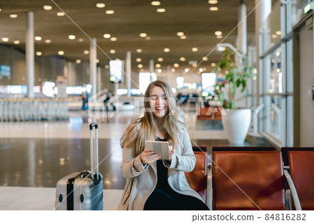 Caucasain young woman using internet by tablet in airport hall n 84816282