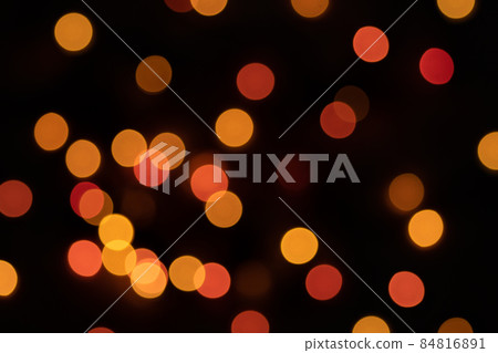 Defocused bokeh lights on black background, an abstract naturally blurred backdrop for Christmas eve or birthday party. Festive light texture. Yellow and red garland in blur. Overlay effect for design Defocused bokeh lights on black background, an abstract naturally blurred backdrop for Christmas eve or birthday party. Festive light texture. Yellow and red garland in blur. Overlay effect for design 84816891