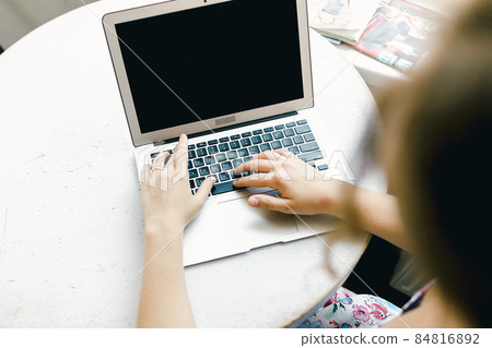 Blurry girl working with laptop, focus on computer. Blurry girl working with laptop, focus on computer. 84816892