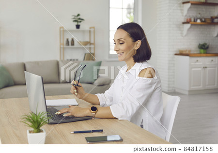 Smiling middle-aged Caucasian businesswoman work online on laptop in home office. Happy successful woman use computer browse wireless internet text message on device. Technology concept. Smiling middle-aged Caucasian businesswoman work online on laptop in home office. Happy successful woman use computer browse wireless internet text message on device. Technology concept. 84817158
