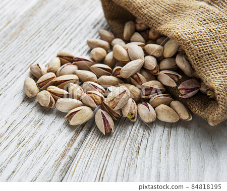 Sack with pistachios on a wooden table Sack with pistachios on a wooden table 84818195