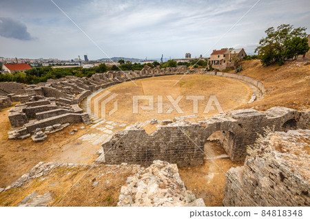 Ruins of the amphitheater of archaeological roman settlement in 84818348