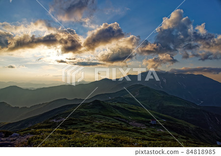 Asahi mountain range, Mt. Itoh and fox hole hut bathing in the setting sun 84818985