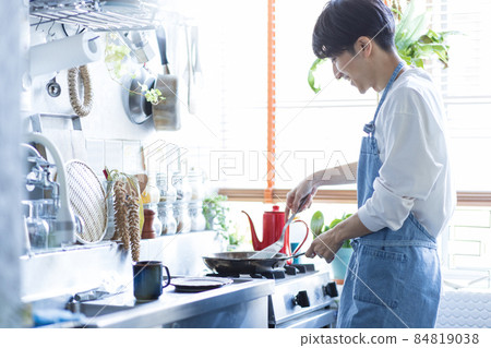 Young man cooking in the kitchen Young man cooking in the kitchen 84819038
