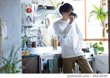 Young man drinking coffee in the kitchen Young man drinking coffee in the kitchen 84819040