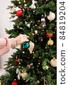 woman is decorating Christmas tree 84819204