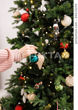 woman is decorating Christmas tree woman is decorating Christmas tree 84819204