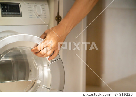 Man is using the modern washing mashine. Man is using the modern washing mashine. 84819226