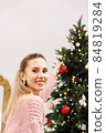 woman is decorating Christmas tree 84819284