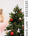 woman is decorating Christmas tree 84819285
